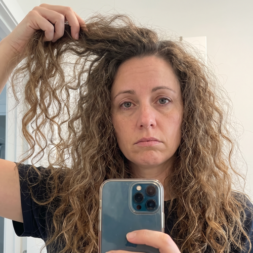 Vrouw bekijkt een droge haarpunt in natuurlijk licht
